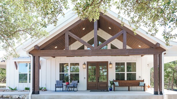 A covered porch with a wooden beam structure, a bench, and two chairs. - Day Drippin’ Farmstay (Dripping Springs)