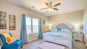A bedroom with a bed, a chair, a nightstand, a ceiling fan, and a window. - NEW Condo: No stairs, Arcade 🎮, Branson Skyline & Ozarks Views, 1GB WiFi! (Branson)