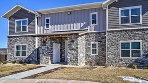 A two-story house with stone cladding and a covered front porch. - NEW Condo: No stairs, Arcade 🎮, Branson Skyline & Ozarks Views, 1GB WiFi! (Branson)