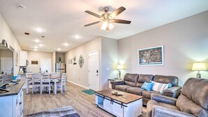 A spacious living room with a dining area, a kitchen, and a ceiling fan. - NEW Condo: No stairs, Arcade 🎮, Branson Skyline & Ozarks Views, 1GB WiFi! (Branson)