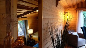 A cozy wooden cabin interior with a bed, a lamp, and a chair.