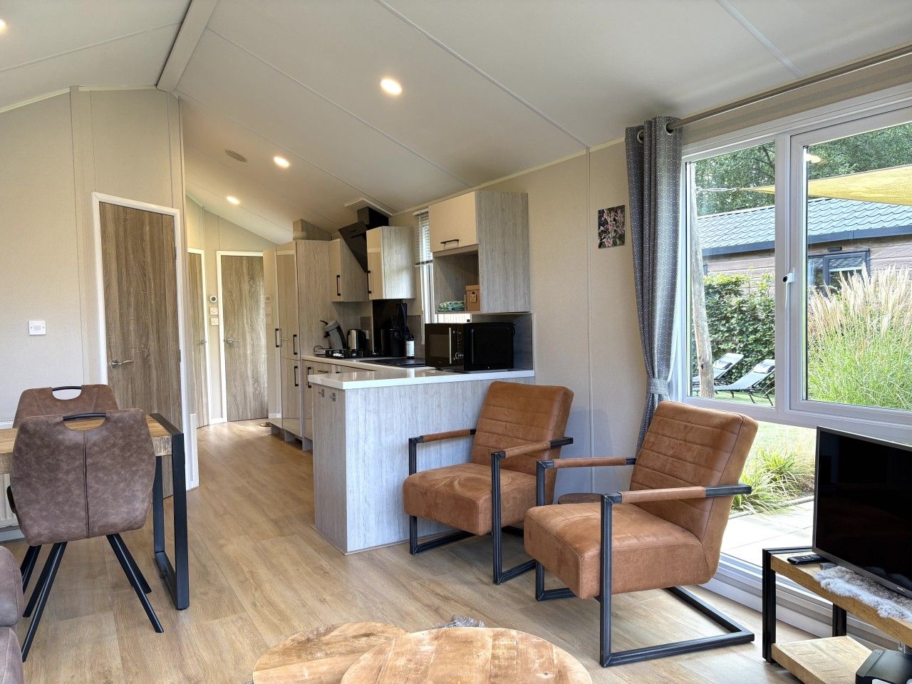 A modern interior with a kitchen, dining area, and a TV.