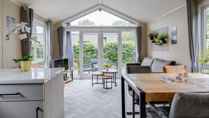 Una cocina moderna con comedor, ventanas amplias y vista al jardín.