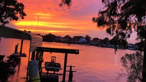 A lakeside view with a dock and boats, surrounded by trees and a sunset. - Waterfront Bayou living only 30 minutes from New Orleans, Dock Fishing (Lafitte)