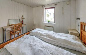 Pieni, yhden huoneen kokoinen majoituspaikka, jossa on sänky, työpöytä, tuoli ja ikkuna.