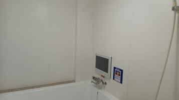 Un baño con una bañera blanca, un panel de control digital y un letrero que indica una instalación CP Plus.