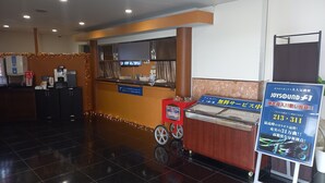 A hotel reception area with a counter, a coffee machine, and a signboard advertising a sound system. - HOTEL C-PLUS - Adults Only (Gyoda)