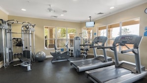 Ein Fitnessstudio mit Laufbändern, Kraftgeräten und einem großen Trainingsball.