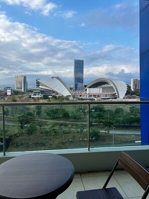 Un balcon offrant une vue sur le paysage urbain, avec notamment un stade et des bâtiments modernes.
