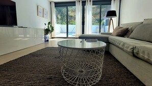 A modern living room with a glass coffee table, a sofa, and a TV. - Villa with beautiful swimming pool  (CT)