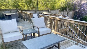 A wooden deck with outdoor furniture including sofas and a table.