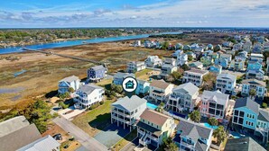 A coastal residential area with houses, a pier, and a large body of water.