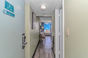 A hotel hallway with a 'Non-Smoking Room' sign, a door with a number '2745', and a view into a room with a window and a chair. - Sand Dunes 2745 (Myrtle Beach)