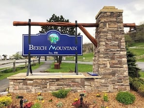 Segnaletica per Beech Mountain con un muro in pietra e una struttura in travi di legno.