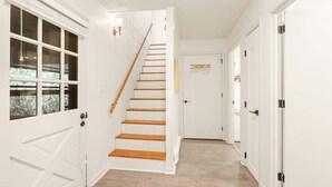 A hallway with white walls, a wooden staircase, and a door with a sign. - 4BR Chalet-A/C-New deck! Calm Creek-Quiet-2 Kings (Beech Mountain)