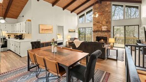 A spacious living area with a wooden ceiling, a fireplace, and large windows. - 4BR Chalet-A/C-New deck! Calm Creek-Quiet-2 Kings (Beech Mountain)