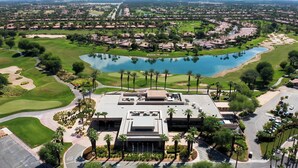 An aerial view of a golf course with a large building in the foreground, surrounded by residential areas and a body of water. - PGA West-Catching Sunsets-3bd 2ba in Signature (La Quinta)