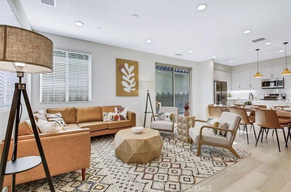 A modern living room with a sofa, coffee table, and dining area.