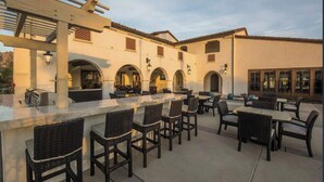 An outdoor patio with a bar area, seating, and a pergola structure. - PGA West-Catching Sunsets-3bd 2ba in Signature (La Quinta)