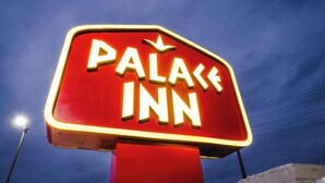 A neon sign for a "Palace Inn" against a twilight sky. - Palace Inn (Humble)