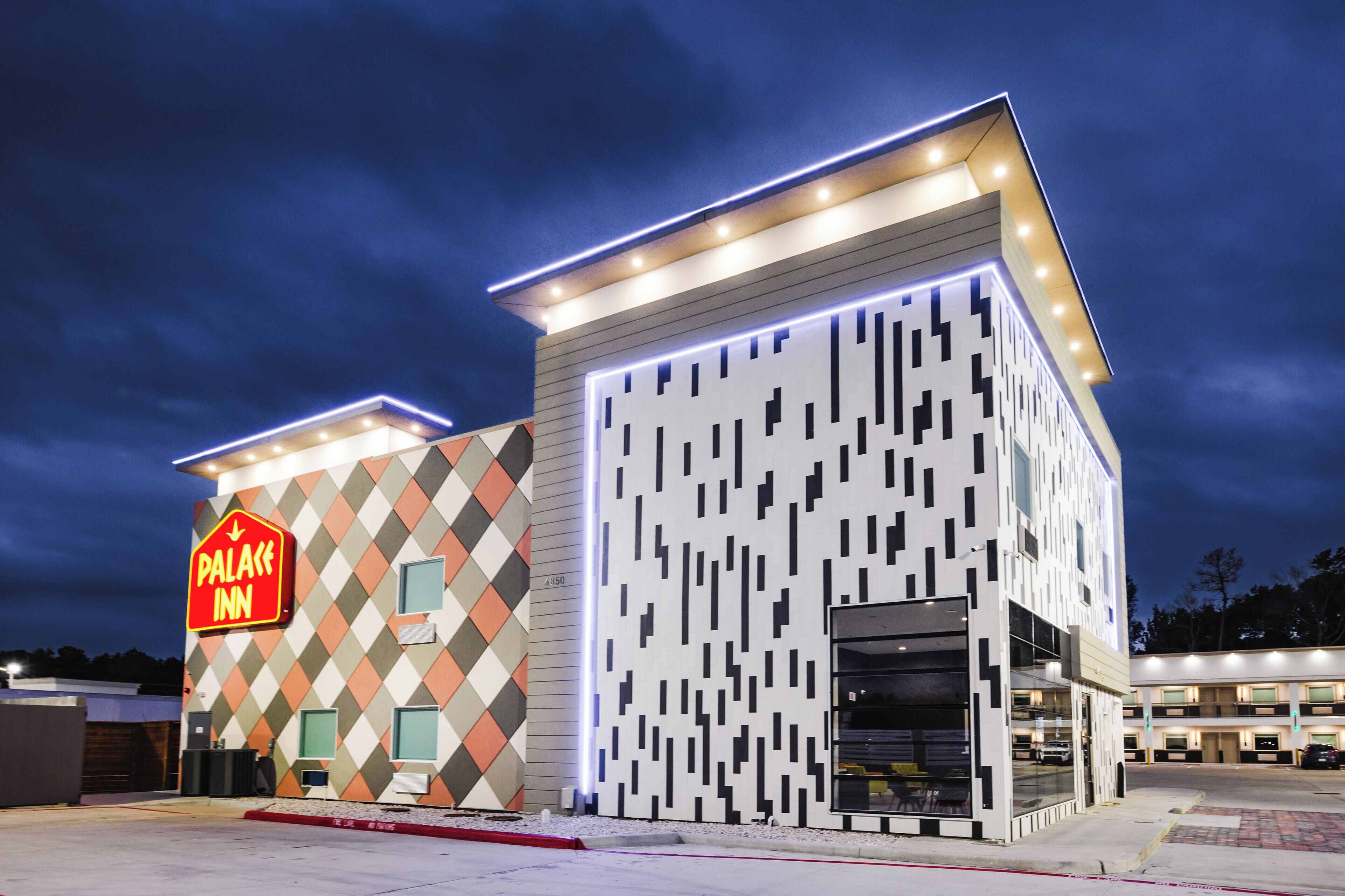 A modern building with a sign reading "Palace Inn" and a geometric facade.