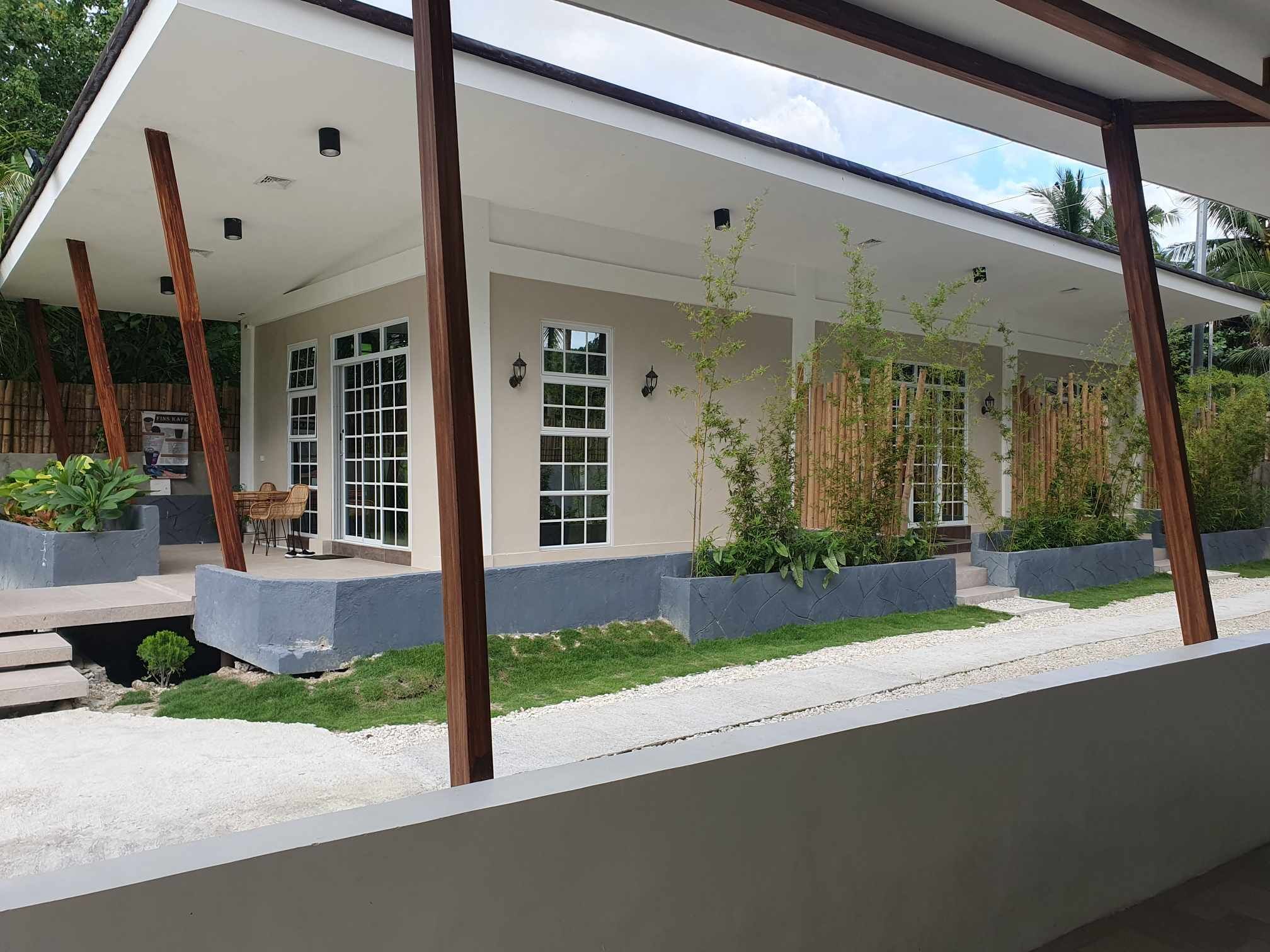A modern building with a covered patio area, large windows, and outdoor seating.