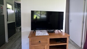 Een houten tv-meubel met een flatscreen televisie, dvd-speler en een spelconsole.