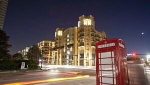Un edificio moderno con una cabina telefónica roja destacada, identificada con el rótulo "Upper Kirby".