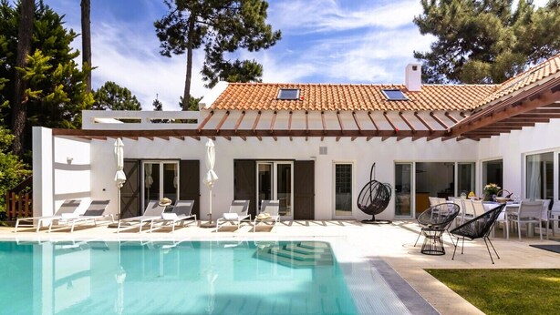 A modern house with a swimming pool, outdoor seating, and a patio area. - Villa da Oliveira with Pool - Golf Aroeira (Herdade da Aroeira)