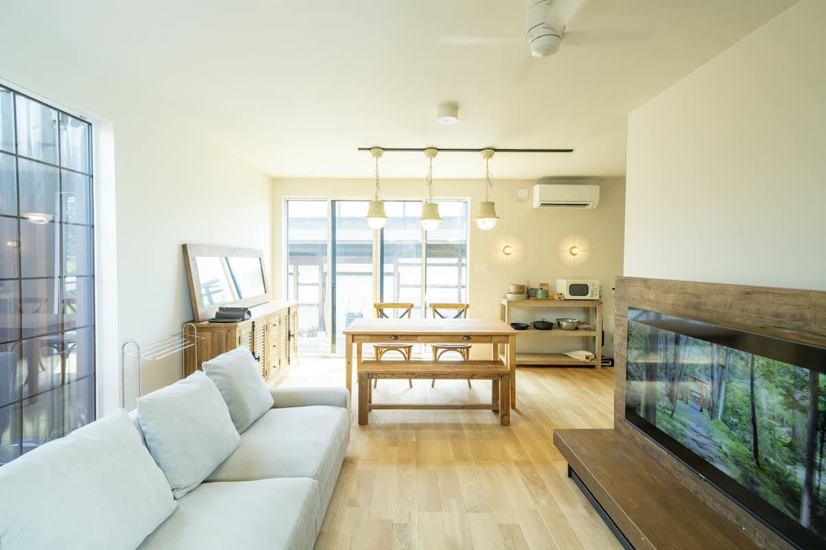 A modern living room with a sofa, dining table, and TV.