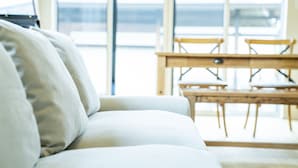 A modern living room with a sofa, a wooden table, and chairs. - raw_ (Hakuba)