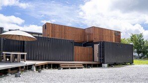 A modern building with a wooden deck and a covered seating area. - raw_ (Hakuba)