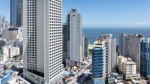 A high-rise hotel with multiple floors, a modern architectural design, and a view of the sea. - Marysol by haeundae beach (Busan)