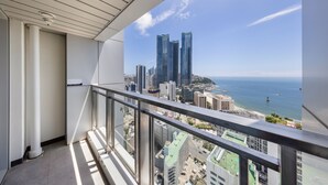 A balcony with a cityscape view, including tall buildings and a beach. - Marysol by haeundae beach (Busan)