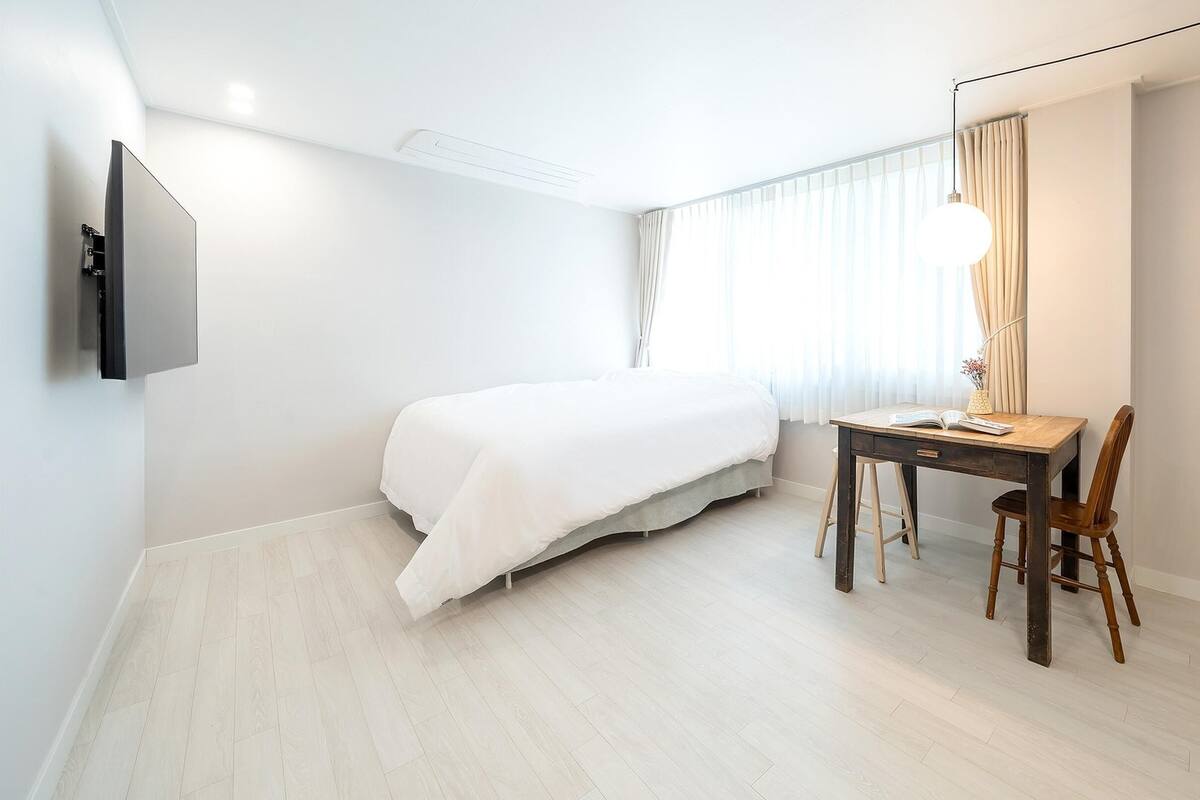 Ein Schlafzimmer mit einem Bett, einem Schreibtisch und einem Stuhl.
