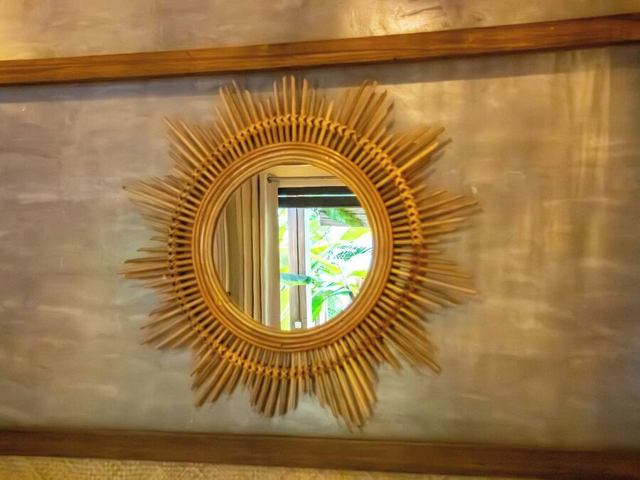 A wall-mounted mirror with a sunburst frame.