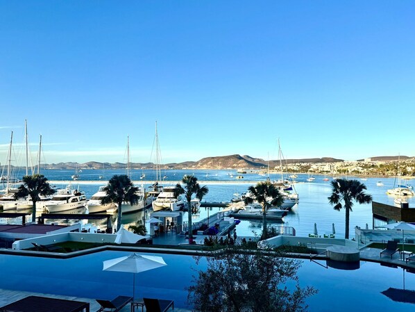 Uma marina com barcos, piscina e vista para o litoral.