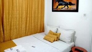 A bedroom with a bed, a painting of a horse, and a curtain. - NINI nini (Bogotá)
