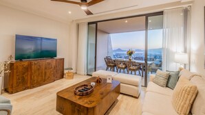 A modern living room with a flat-screen TV, wooden coffee table, and a sofa. - Casa Kavita Mistiq | El Tezal Luxury Penthouse Condo (El Tezal)