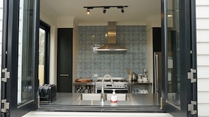 A modern kitchen with a stainless steel range hood, a built-in oven, and a sink with a soap dispenser. - Chevignon country charm in the heart of town (Queenscliff)