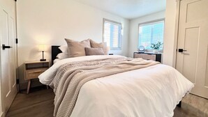 A bedroom with a bed, bedside tables, a lamp, and a ceiling light fixture.