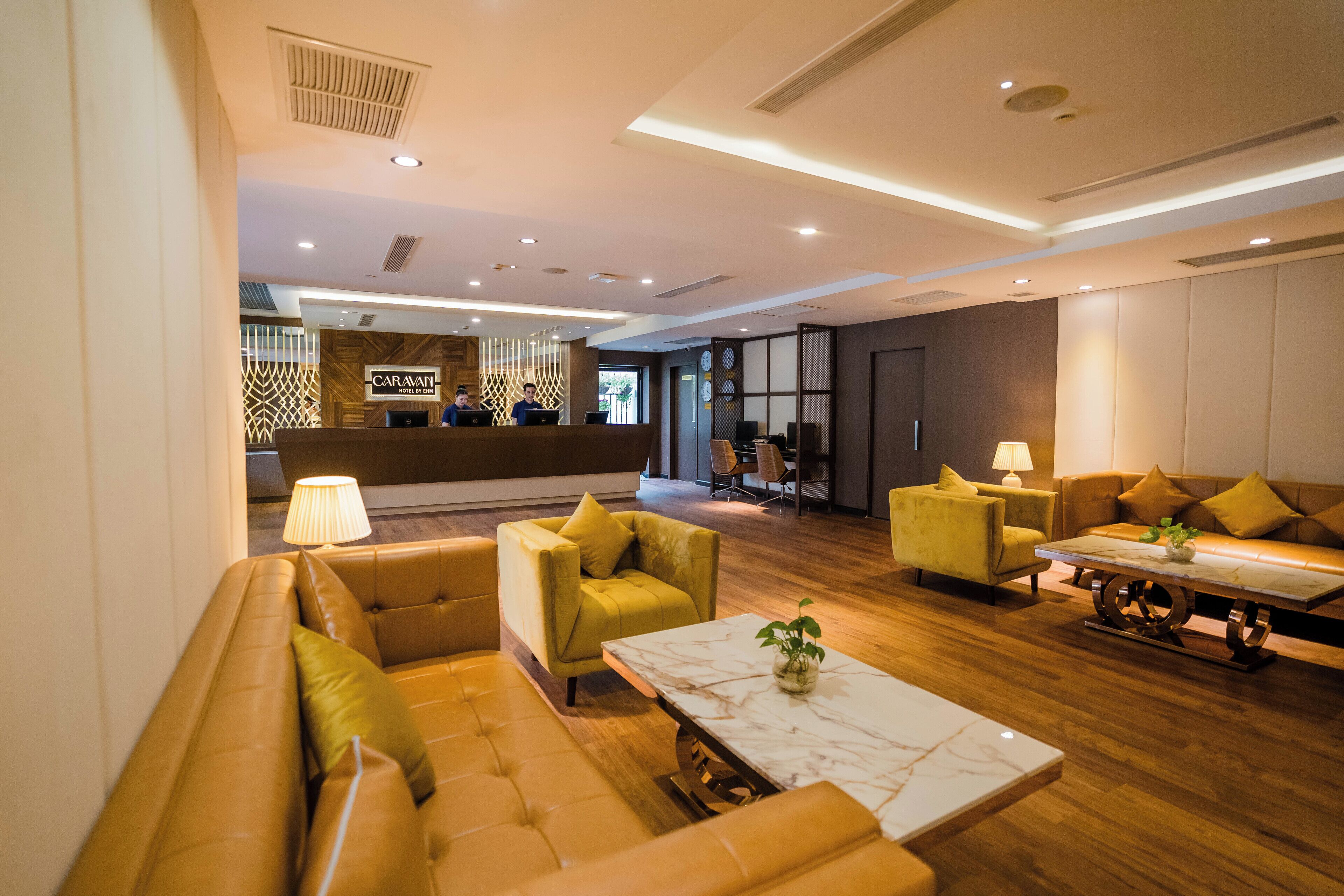 Eine moderne Lobby mit Empfangstresen, Sitzgelegenheiten und Holzboden.