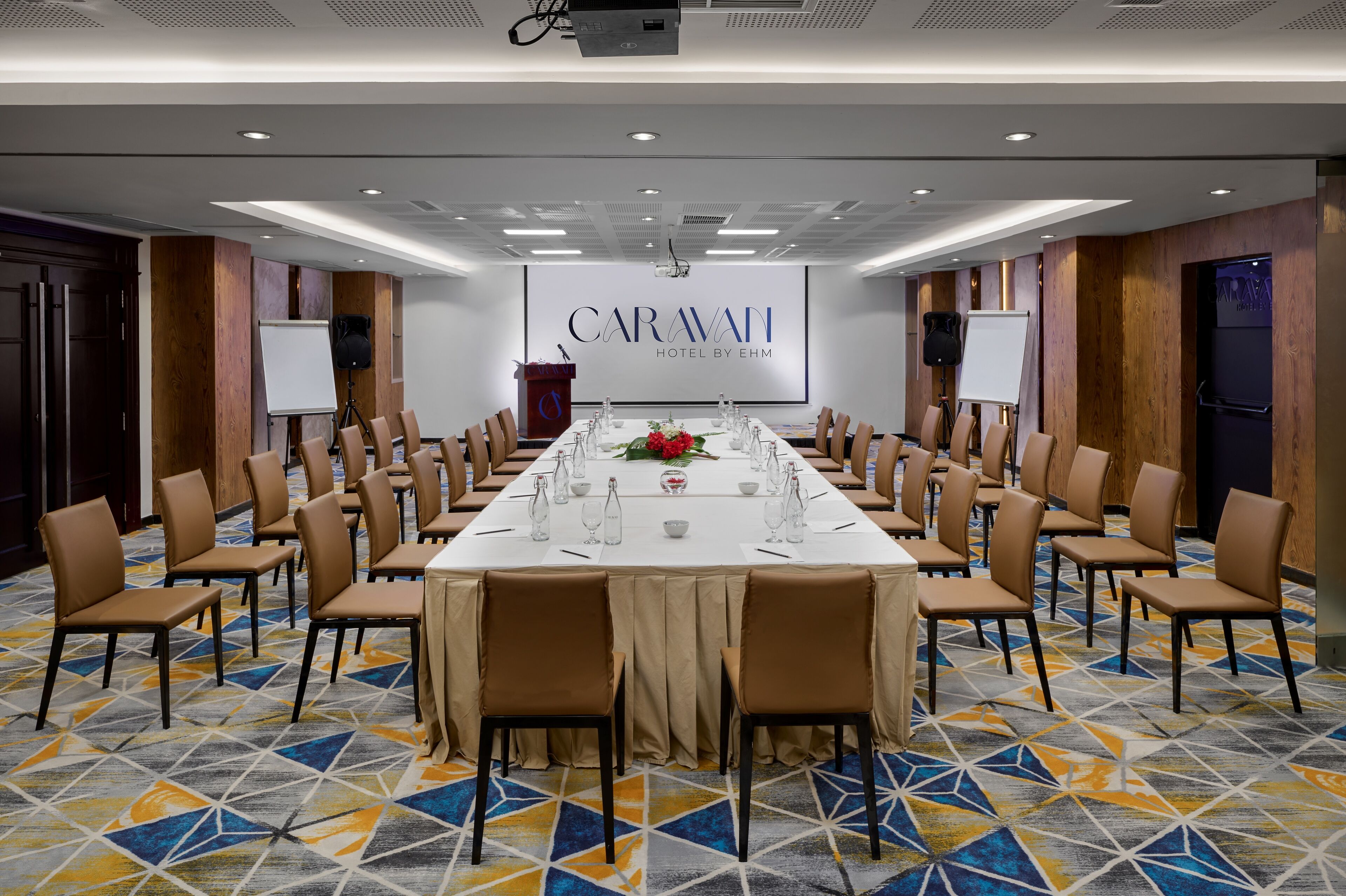 A conference room with a long table, chairs, and a whiteboard.