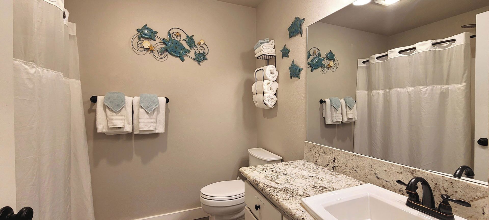 A bathroom with a toilet, sink, and towel rack.