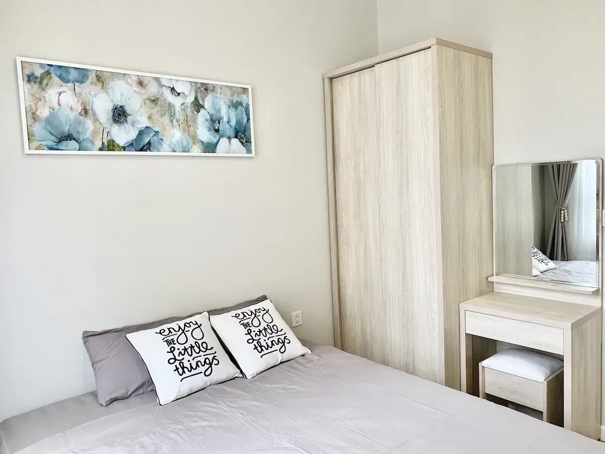 A bedroom with a bed, a dresser, a mirror, and a floral painting on the wall.