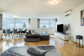 Un salon moderne comprenant un canapé, un coin repas et un téléviseur.