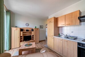 A compact living space with a kitchenette, a dining area, and a seating area. - Apartment 'Abendrot' with Wi-Fi (Ostseebad Kühlungsborn)