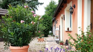 A pathway leading to a house with a potted plant and flowers. - Lakefront Holiday Cottage with Private Terrace and Wi-Fi (Bestensee)