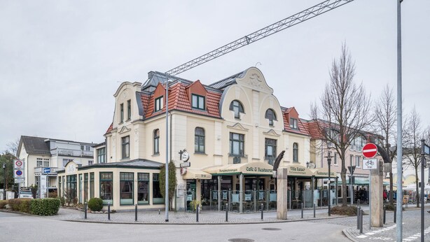 A building with a cafe and restaurant on the ground floor, a no entry sign, and a bicycle parking sign. - Apartment 'Morgensonne' with Wi-Fi (Ostseebad Kühlungsborn)