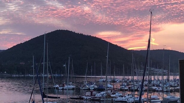 A marina with boats docked, a hill in the background, and a sunset sky. - Apartment 'Fewo Am Edersee' with Private Garden, Balcony and Wi-Fi (Edertal)